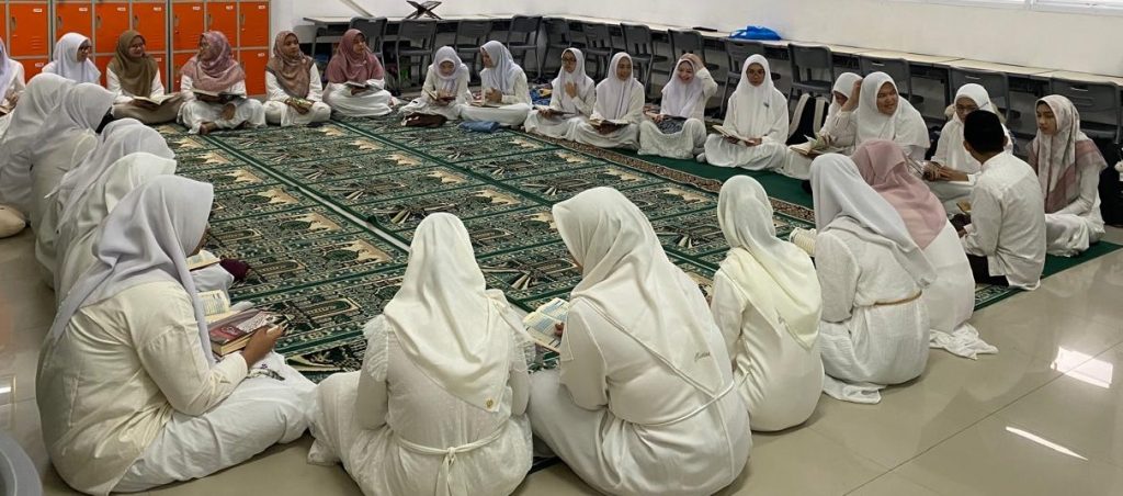 Murid-murid SMA Islam Al Azhar 22 Cikarang berpakaian putih sedang duduk melingkar di atas karpet sajadah untuk tadarus Al-Qur'an dan kegiatan keagamaan.