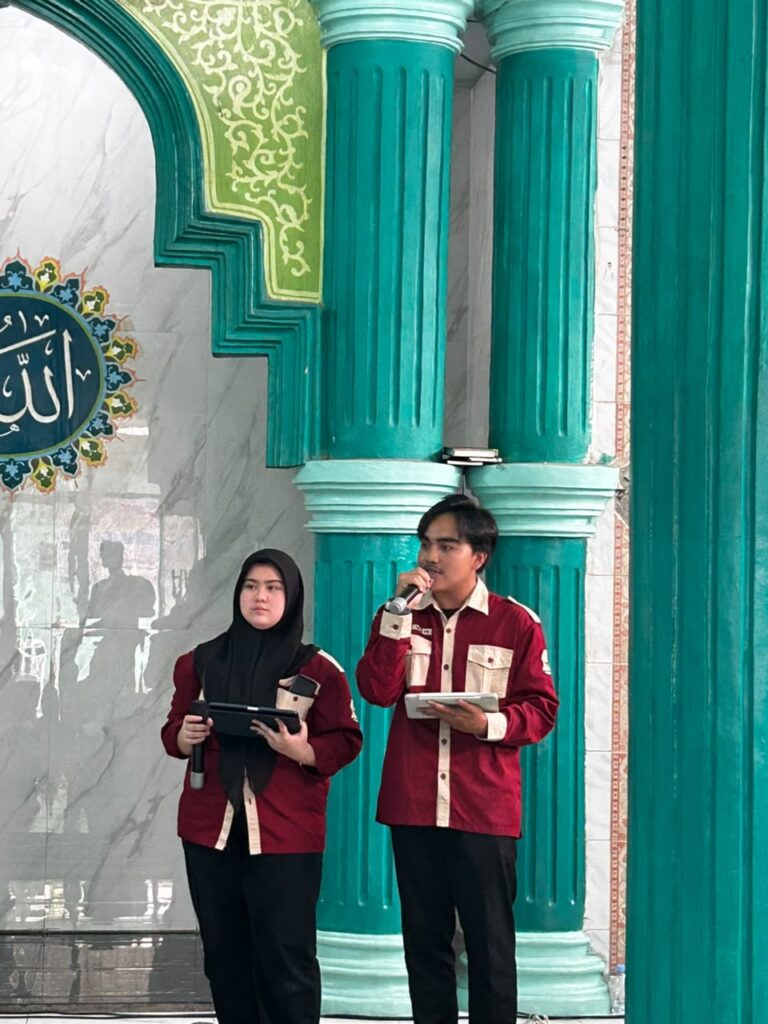 Dua pengurus OSIS SMA Islam Al Azhar 22 Cikarang berbaju marun menjadi pembawa acara (MC) di area masjid.